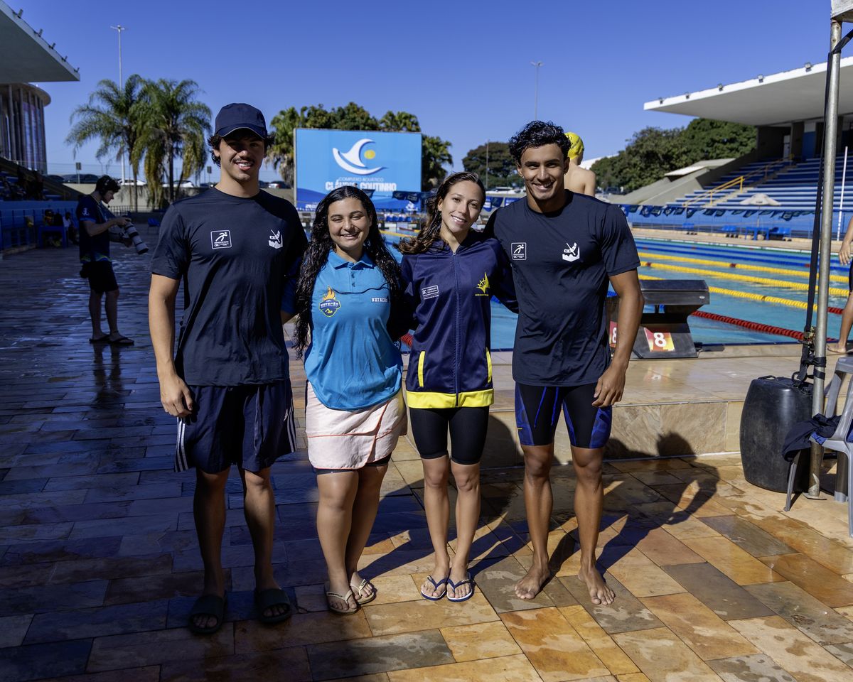 Quatro atletas do Distrito Federal posam à beira da piscina de competição