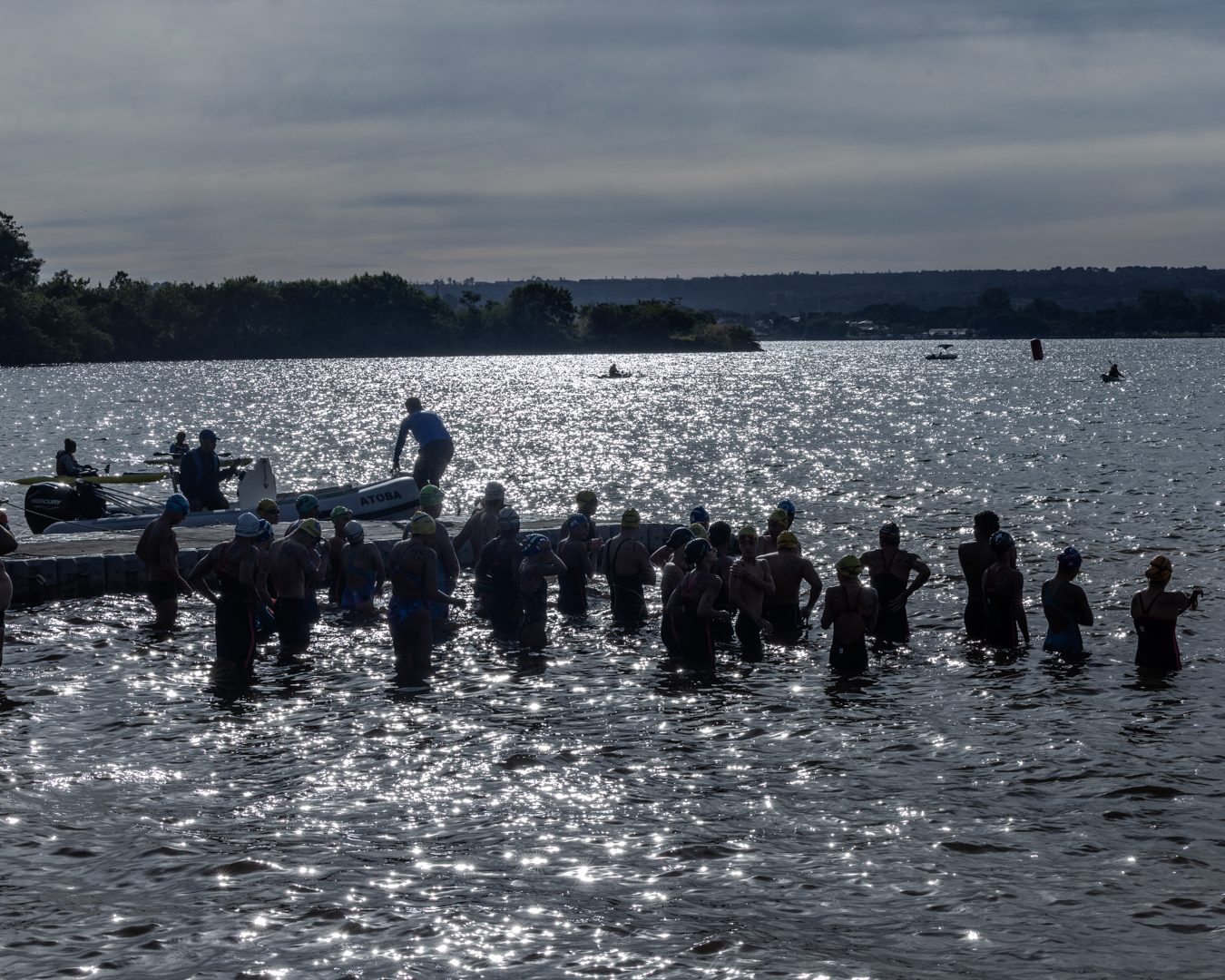Atletas reunidos na água antes da largada de uma prova de águas abertas no Lago Paranoá, em Brasília.
